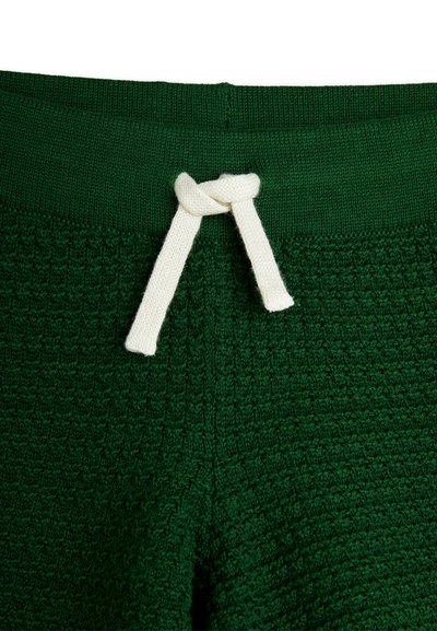 Green textured pants with a thick waistband and a white drawstring tie. Features a patterned knit design.