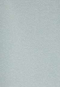 Light blue cotton fabric with a smooth, slightly textured surface and even stitching, suitable for casual wear or layering.