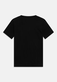 Jednoduché černé tričko s krátkým rukávem, položeno na rovně, ukazuje zadní stranu na neutrálním světle šedém pozadí.