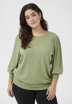 Green knit sweater with pleated balloon sleeves, round neckline, and ribbed cuffs. Soft texture, relaxed fit, and hemline at the hip.