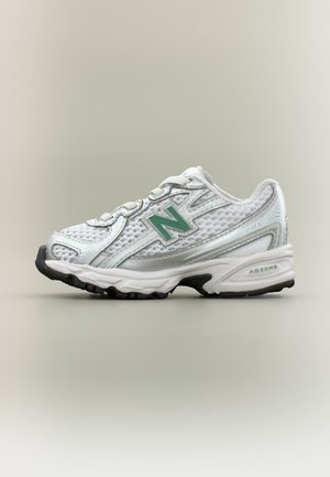 Witte en grijze New Balance hardloopschoen met groen logo en zwarte zool op een neutrale achtergrond, zijaanzicht.