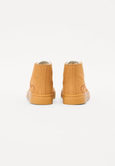 Botine ancle bej din pânză, cu o suprafață texturată, având un design înalt și o talpă din cauciuc, detalii de cusătură vizibile și un logo subtil.