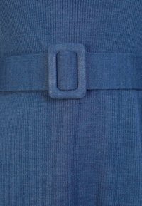 Blaues gestricktes Kleid mit einem strukturierten Rippenmuster und einem festen Stoffgürtel mit einer quadratischen Schnalle in der Taille.