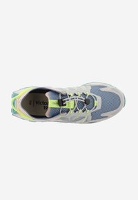 Zapato deportivo con parte superior de malla en azul claro, acentos grises y cordones en amarillo neón. Presenta una suela texturizada y un collar acolchado.