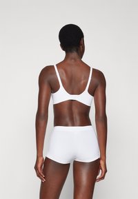White cotton bra and shorts set with adjustable straps. Seamless design, smooth texture, and minimalistic style.