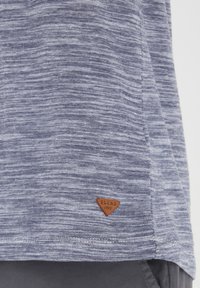 Kortærmet navy og hvidstribet T-shirt med en tekstureret stof. Har et lille brunt trekantet mærke med "BLEND 1993."