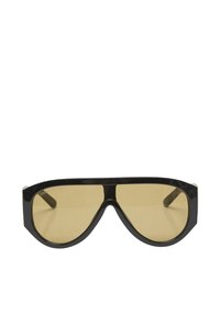 Lunettes de soleil à monture noire avec un grand design à lentille unique et des verres teintés jaune, présentées sur fond blanc.