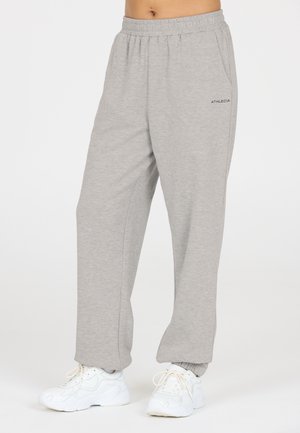 Jogging en mélange de coton gris avec une taille élastique et des poignets élastiques. Comprend des poches latérales et un petit logo noir sur la cuisse.