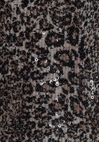 Sort og brun leopardprintstof pyntet med tæt spredte, skinnende sorte og sølvfarvede palietter.
