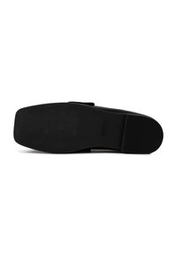 Suela de zapato negro con una superficie lisa y plana, que presenta ranuras para tracción y un logotipo estampado. El material parece ser de goma con un acabado mate.