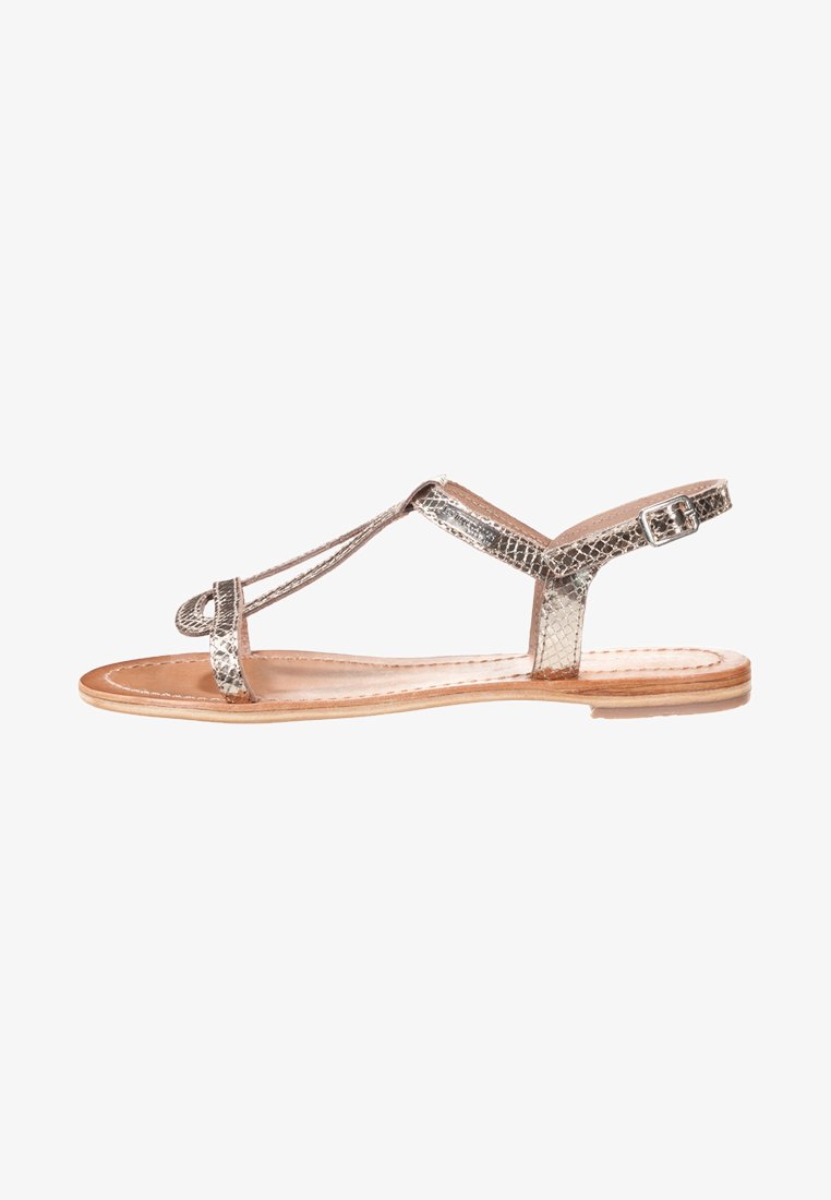 Silver metallic, snake-skin pattern flat sandal with a T-strap design, adjustable ankle buckle, and a natural leather insole.