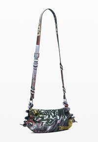 Malá crossbody taška z vzorovanej syntetickej látky; má volánové okraje, nastaviteľný popruh a kovové detaily. Farby zahŕňajú zelenú, ružovú a žltú.