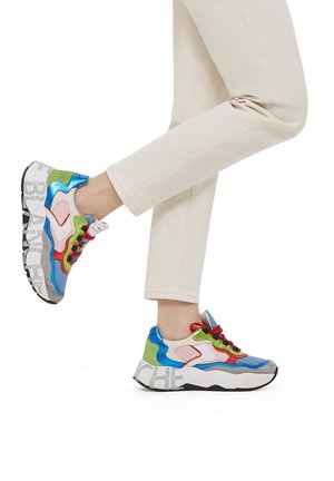 Zapatillas deportivas voluminosas multicolores que presentan texturas como materiales suaves, brillantes y de ante, con cordones rojos y la palabra 'BLANCHE' impresa en la suela.