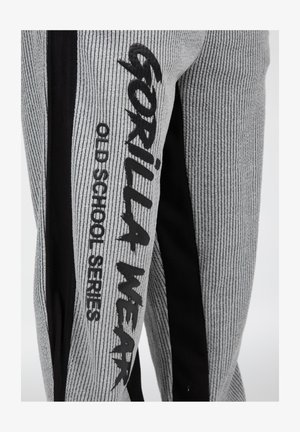 Grijze en zwarte sportbroeken met een geribbelde textuur, voorzien van het "GORILLA WEAR OLD SCHOOL SERIES" logo in vet zwart op de zijkant.