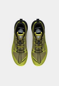 Πράσινα και κίτρινα αθλητικά παπούτσια με υφή στον άνω μέρος, μαύρες λεπτομέρειες και ασφαλές σύστημα κορδονιών. Διαθέτουν μια διακριτική ετικέτα λογότυπου.