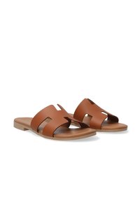 Brune læder slide sandaler med udskårne design, flade såler og en glat finish. Minimalistisk stil med åben tå og åbninger på siden.