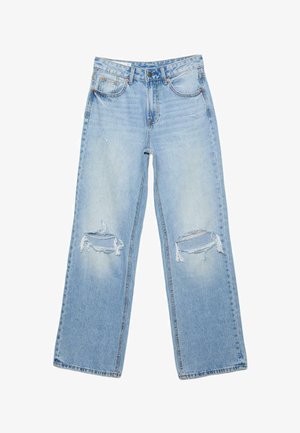 Svetlomodré riflové nohavice s vysokým pásom, rovnými nohavicami a veľkými roztrhnutými dierami na oboch kolenách.