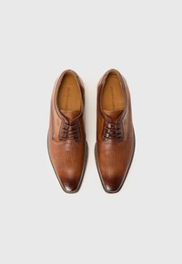 Chaussures habillées en cuir marron avec une surface texturée, un embout pointu, un laçage à l'avant et des accents lisses. Semelle durable, une maîtrise artisanale visible.