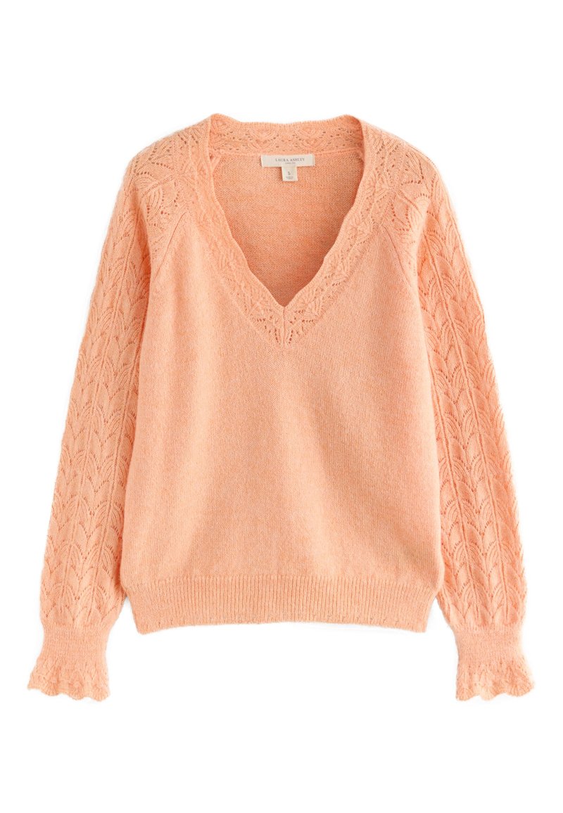 Brzoskwiniowy sweter z dekoltem w serek, teksturowanymi koronkowymi rękawami i dopasowanym dołem. Na rękawach misterny wzór liści. Miękki materiał.