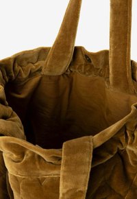 Bruine fluwelen gewatteerde schoudertas met brede schouderbanden en een drukknoopsluiting, van bovenaf getoond met een open top.