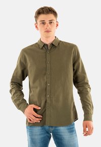 Olijfgroene, langmouwenshirt met een knoopsluiting aan de voorkant, gemaakt van lichtgewicht stof; heeft een standaardkraag en subtiele structuur.