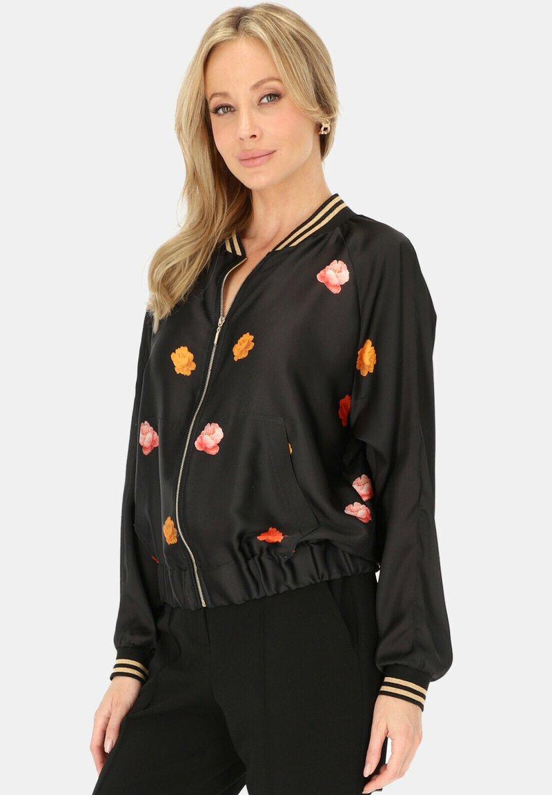 Czarna satynowa kurtka bomberka z wielokolorowym haftem kwiatowym, ściągacze przy kołnierzu i mankietach z złotymi akcentami oraz zamek błyskawiczny.