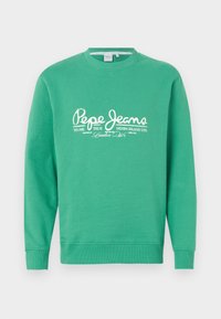 Sudadera verde hecha de un tejido suave, con un cuello redondo y mangas largas. En la parte delantera muestra letras y detalles del logo en blanco.