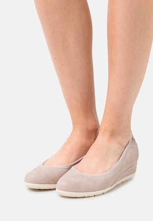 Beige wedge schoenen met een getextureerd gaas bovenwerk, ronde neus en gladde details. Voorzien van een lage sleehak en een flexibele rubberen zool.