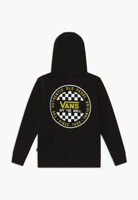 Sudadera negra con capucha que presenta un gran logo circular de Vans en amarillo y blanco con un patrón de cuadriculado en el centro.