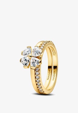 Anello Pandora in oro con quattro pietre trasparenti a forma di cuore che formano un quadrifoglio e piccole pietre rotonde che decorano la fascia.