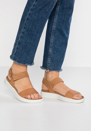 Sandali in suede marrone con più fasce e una cinghia alla caviglia regolabile. Presentano una suola in gomma bianca e una texture liscia.