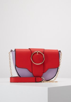 Punainen ja violetti tekonahkainen olkalaukku, jossa on kultaiset pyöreät yksityiskohdat, säädettävä ketjuhihna ja läppäkiinnitys. Erottuva väriblokkausdesign.