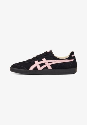 Zwarte lage sneaker met roze strepen, zwarte zool en zwarte veters, weergegeven in zijaanzicht rechts op witte achtergrond.
