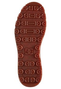 Reddish-brown rubber shoe sole featuring a patterned grip with rectangular and oval shapes, and a central logo accent.