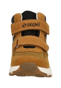 Brune ruskind sneakers med dobbel Velcro-straps, sorte mesh-detaljer og en hvid gummisål; har zigzag-logo på fronten.
