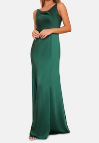 Grön satängklänning med rundad halsringning, figurnära midja och utsvängd kjol. Slät textur, golvlång design och subtil lyster. Inga mönster eller utsmyckningar.