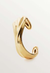 Pulsera de puño de metal dorado con un diseño suave y curvado. Presenta un patrón en forma de ola y extremos abiertos para un ajuste ajustable. Superficie reflectante.