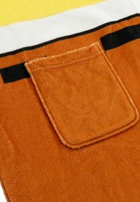 Tessuto in pile arancione con tasca a toppa, caratterizzato da accenti a strisce bianche e nere vicino alla parte superiore. Texture morbida senza un motivo distintivo.