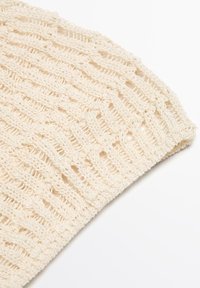 Cappello lavorato a maglia beige con una trama sciolta, caratterizzato da un motivo testurizzato e un bordo arrotolato per un ulteriore dettaglio. Materiale leggero e traspirante.