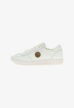 Sneaker bianche in pelle con punta arrotondata, suola piatta bianca, design con lacci e un emblema dorato di leone sul lato.