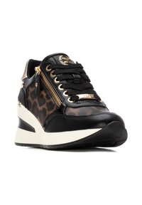 Basket en cuir noir avec des accents en imprimé léopard, détail de fermeture éclair doré et semelle compensée. Présente des lacets noirs et un logo sur la languette.