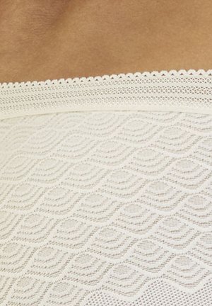 Weißer Spitzenstoff mit einem Wellenmuster und gewellten Kanten. Die Textur ist leicht und luftig mit aufwendigen Details.