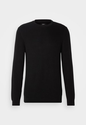 Svart ribbad stickad tröja med rund halsringning och långa ärmar. Materialet verkar mjukt med en strukturerad yta, lämpligt för avslappnad bärning.