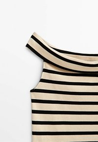 Haut décolleté épaules nu beige avec des rayures horizontales noires. Il présente une texture côtelée et un large décolleté pour le confort.