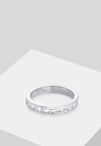 Anello in argento sterling con una fila continua di sette pietre rettangolari trasparenti, finitura lucida e incisa la dicitura "925" all'interno della fascia.
