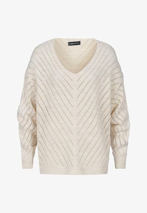 Gaiši ivorijs siltā džemperis ar V veida kakla izgriezumu, pārāk lielu siluetu un atvērto adījuma rakstu ar diognālo svītru un ribētām aprocēm.