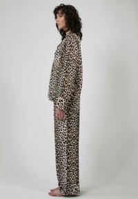 Pyzamový set s leopardím vzorom z jemného materiálu; dlhý rukáv s golierom a zodpovedajúce nohavice; pohodlný strih s minimálnym zdobením.