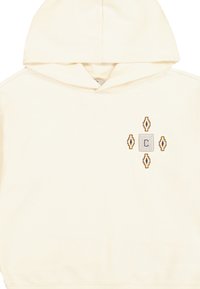 Haut à capuche crème avec une poche kangourou, présentant un logo carré texturé et des motifs en losange en broderie marron et or sur la poitrine.