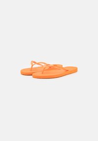 Des tongs orange en caoutchouc, dotées de fines lanières et de semelles plates avec une surface texturée. Conception simple sans motifs supplémentaires.