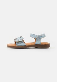 Blauwe suède sandalen met een gestructureerde afwerking, voorzien van een bloemenaccent, verstelbare band en een bruine zool. Ideaal voor warm weer.